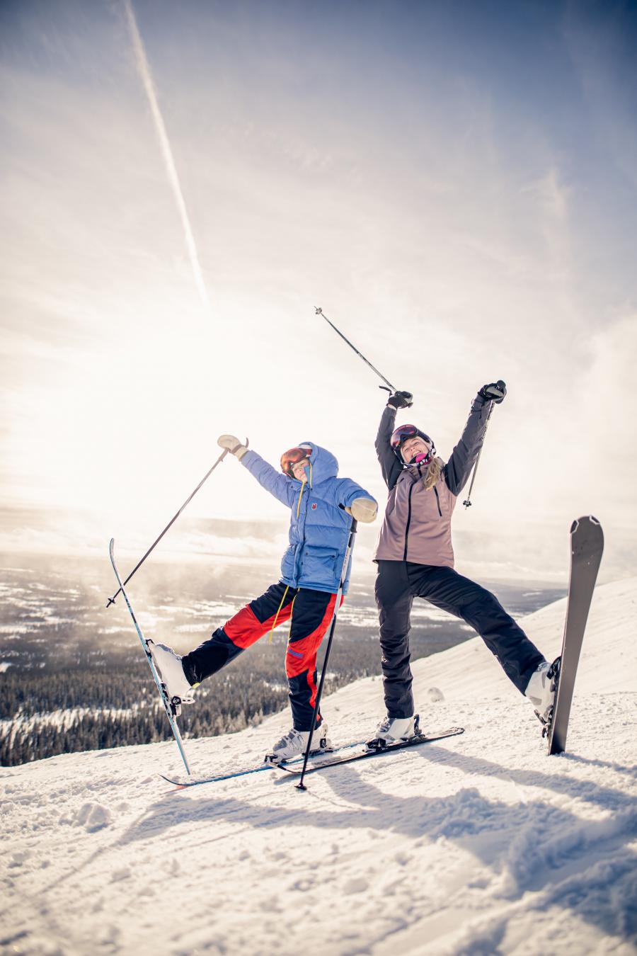 To mennesker på ski poserer for kameraet i et snelandskab
