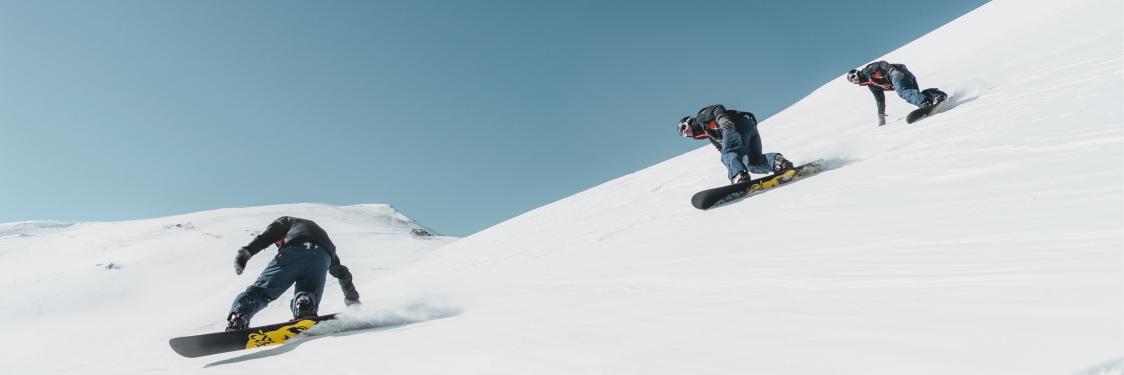 Person på snowboard på vej ned af et sneklædt bjerg